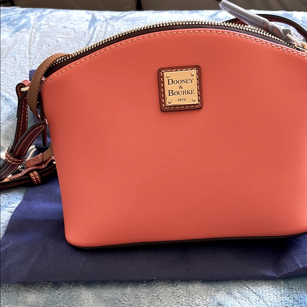 Dooney & Bourke nwt med size cross body with dust cover and zip closure.